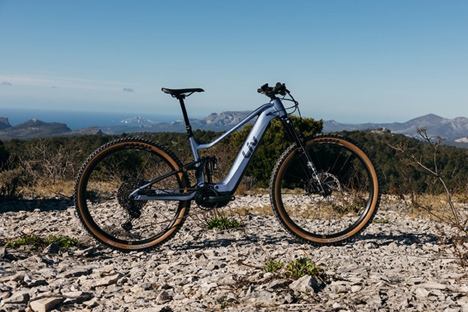 Liv Embolden E+ 2027 elektrokolo pro ženy ve světle šedé barvě na stezce